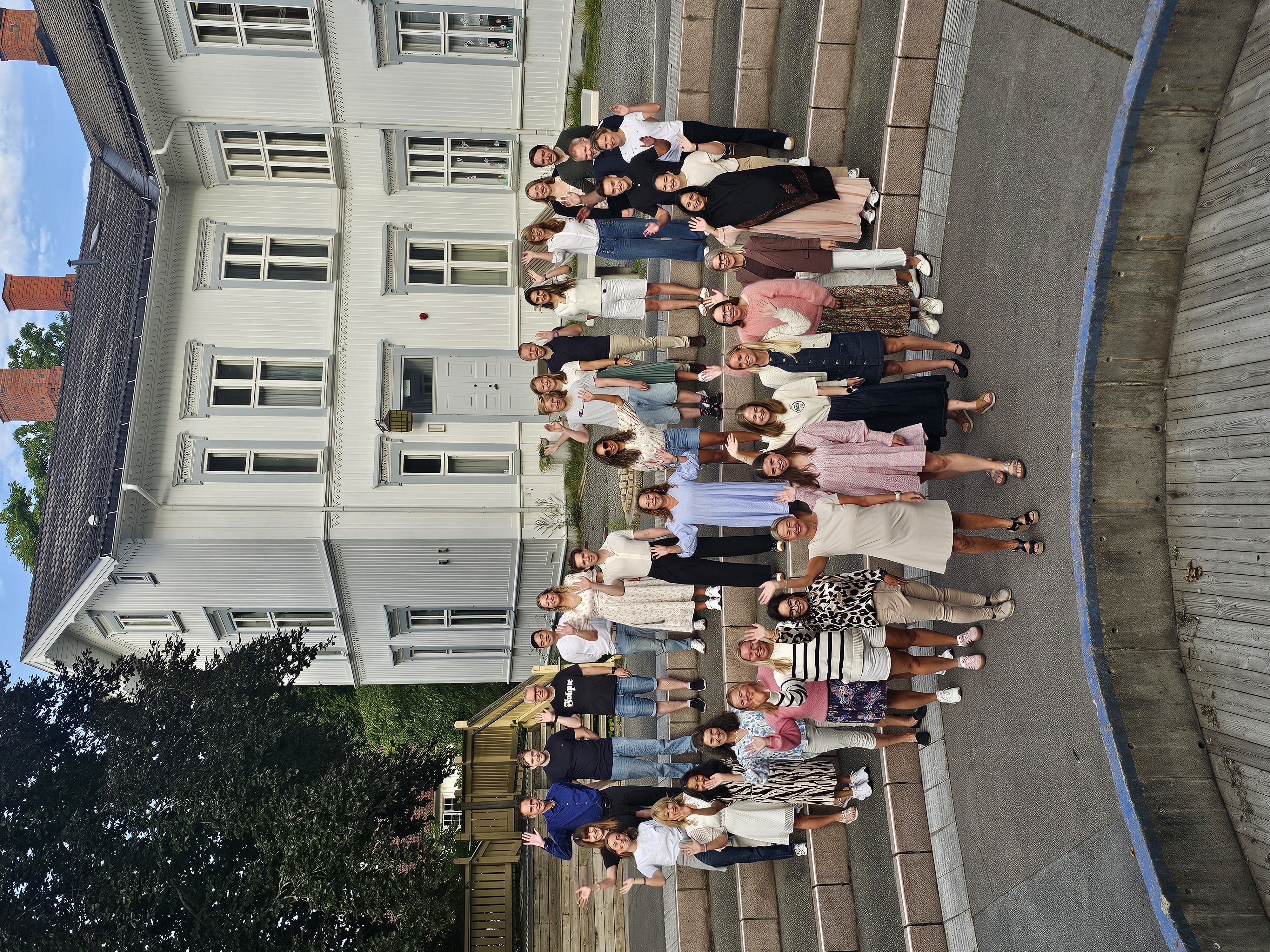 En gruppe mennesker som står foran en bygning