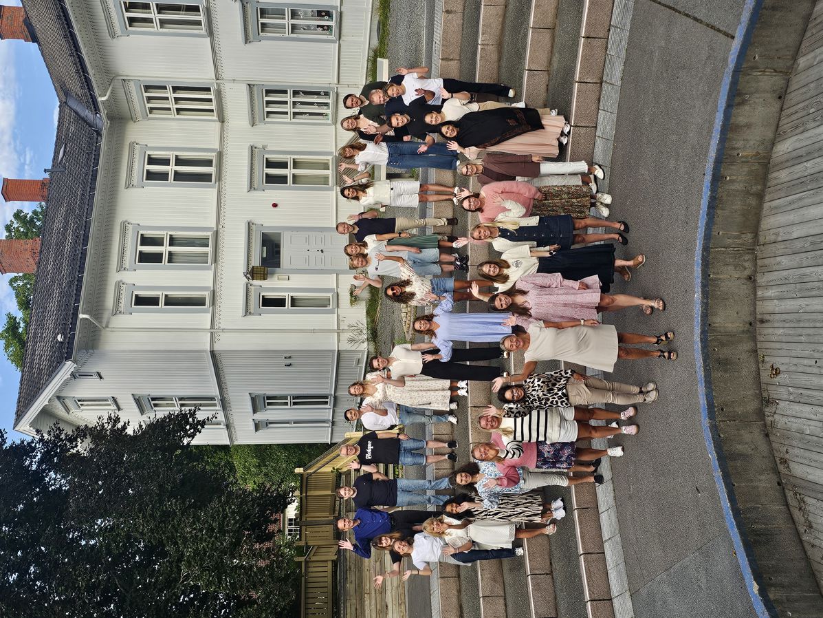 En gruppe mennesker som står foran en bygning