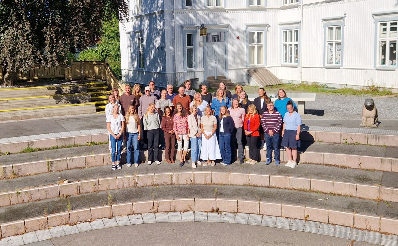 En gruppe mennesker som poserer for et bilde på en steintrapp