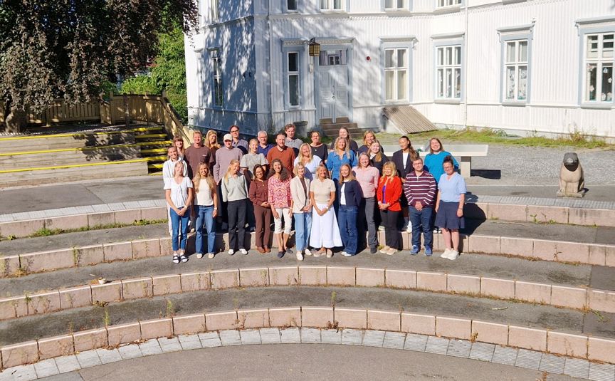 En gruppe mennesker som poserer for et bilde på en steintrapp