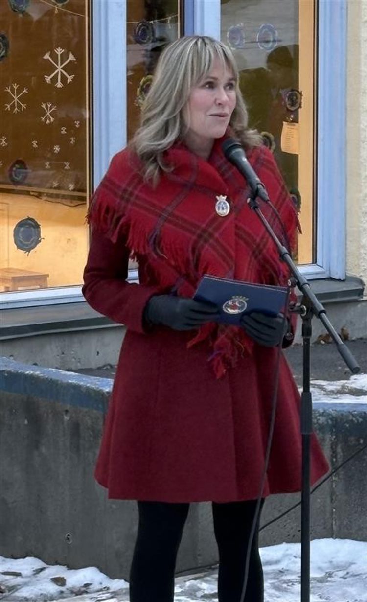 En person i rød frakk som holder en svart gjenstand