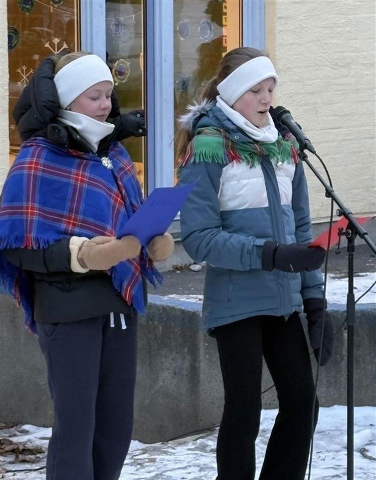 Et par personer med hodeplagg og som holder et ark